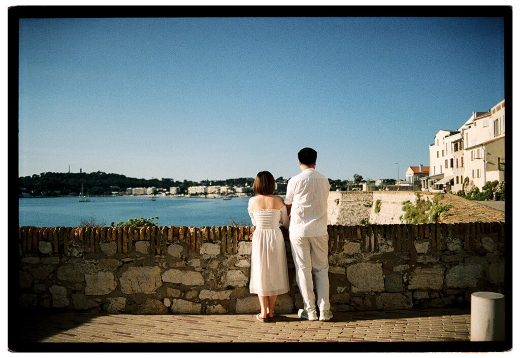 Honeymoon Portrait Photo Shoot in the French Riviera. A couple looking out to sea in Antibes on the French Riviera, photographed on 35mm film